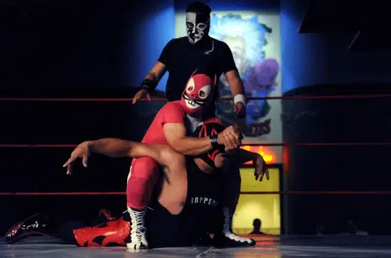 Super Conejo puts a wrestler in a hold at a match in Denver, Colo., on Sunday, May 24, 2009. For the past 3 years IWF Lucha Libre has held authentic Mexican style wrestling matches featuring local and Mexican wrestlers at different venues in Colorado. Matches occur about once per month. El Escorpio is in the background. (Chris Schneider/Chris Schneider Photography)